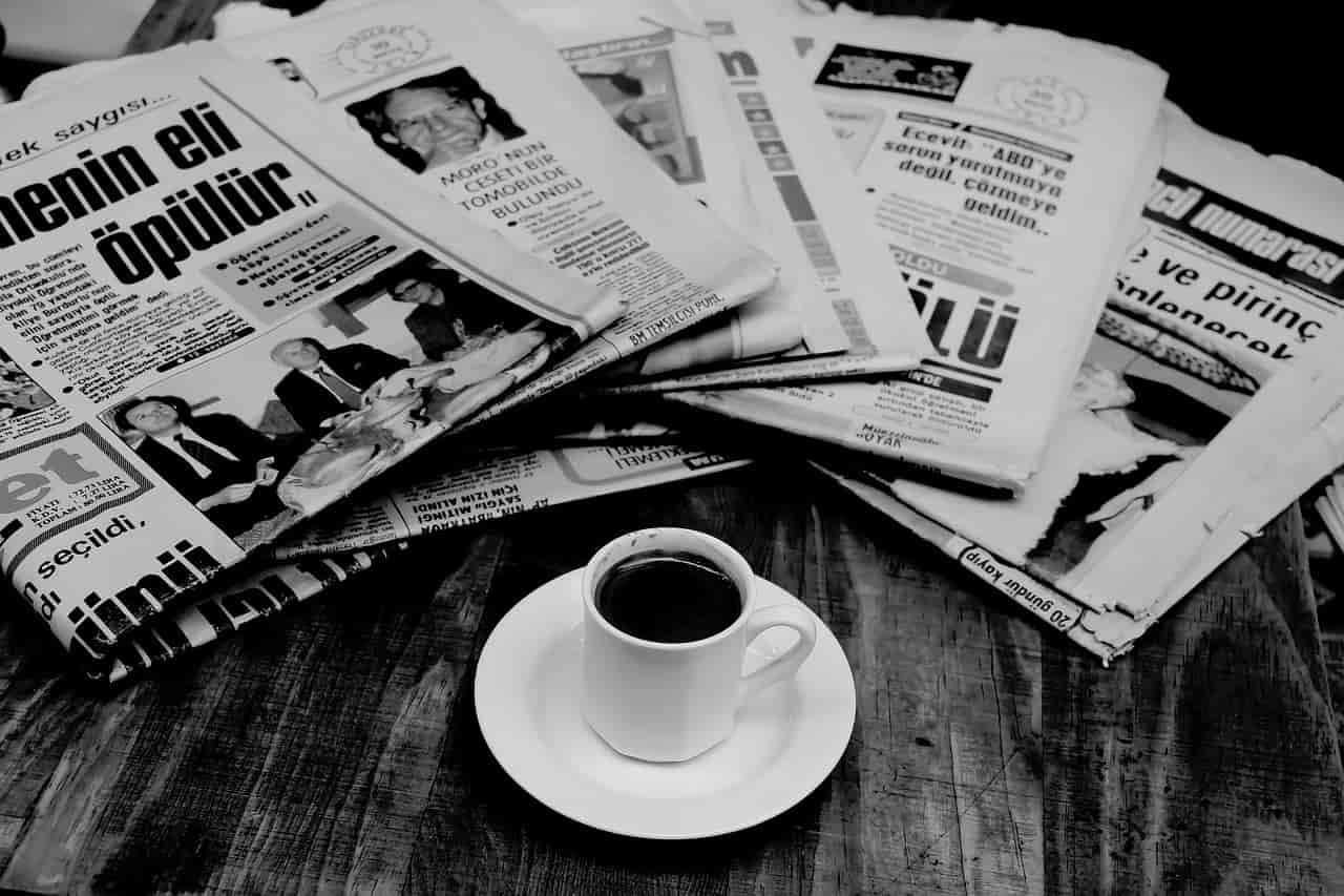 通勤電車で読む新聞と苦そうなコーヒー