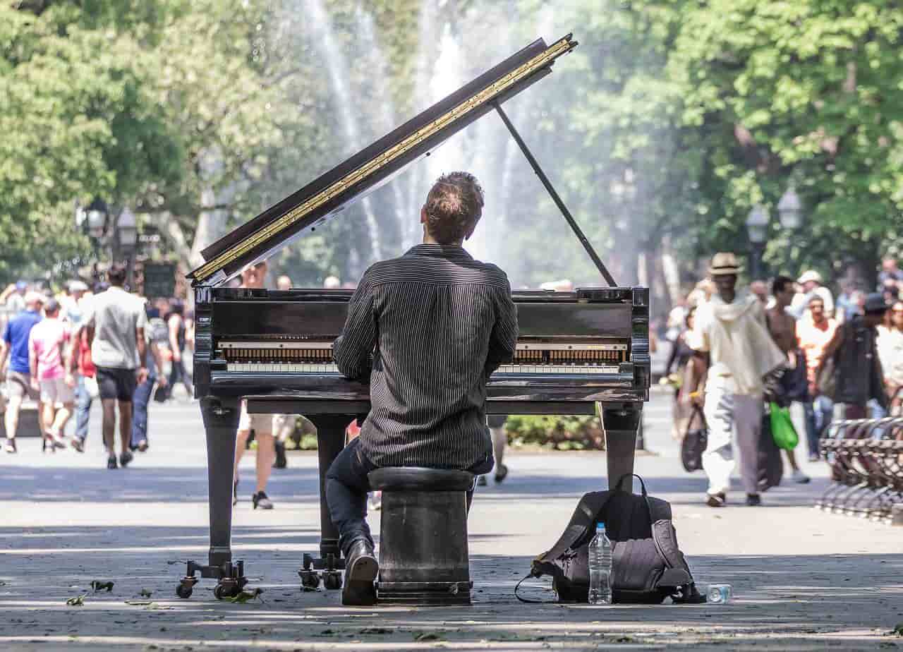 公園で趣味のグランドピアノを弾く男性